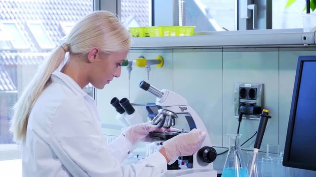 Scientist working in lab. Female doctor making medical research. Laboratory tools: microscope, test tubes, equipment. Biotechnology, chemistry, science, experiments and healthcare concept.
