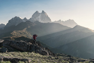 Mountaineer with backpack on rock
