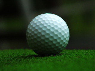 Golf on a green field with a natural sky background That is quite dark closely