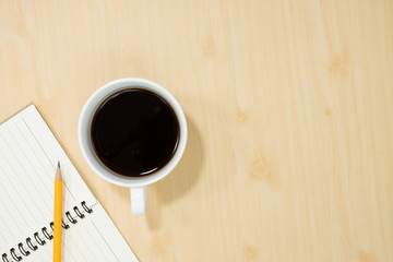 Business concept. Wood office desk table with notebook, cup of coffee,flat lay. Top view with copy space. Office desk table concept.