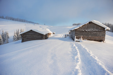 Wonderful winter in the Ukrainian Carpathian Mountains with snow-covered houses and spruce around