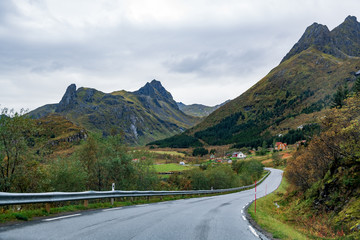 Fototapeta premium Scenic asphalt road through the beautiful view of mountain in lofoten island, Norway during autumn. Concept of roadtrip, travel, vacation, adventure