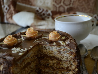 Cake with nuts and meringues decorated with cream rose. Shallow depth of field, close-up.