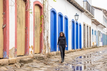 Beautiful young teenage girl walks lonely on stone street