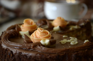 Cake with nuts and meringues decorated with cream rose. Shallow depth of field, close-up.