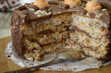 Cake with nuts and meringues decorated with cream rose. Shallow depth of field, close-up.