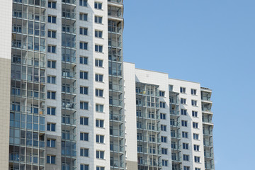 Fototapeta na wymiar Modern high-rise apartment building at blue sky background