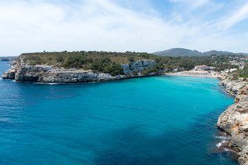 People relax on the beach in the Bay of Cala Romantica in Mallorca
