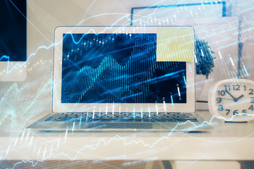Financial chart drawing and table with computer on background. Multi exposure. Concept of...