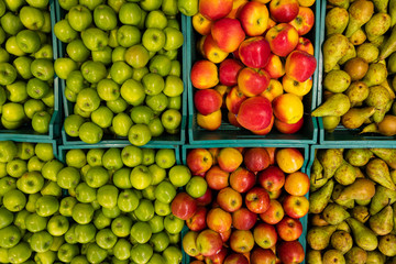 Top view at green and red crispy apple and pears in containers