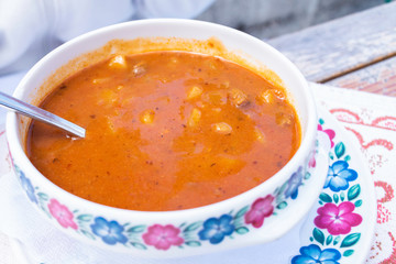 Borsch with tomatoes on wooden table