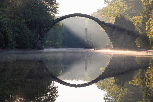 Alte Steinbr&uuml;cke in Deutschland spiegelt sich im Wasser 