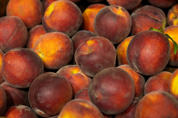 Close-up of ripe red-yellow peaches on supermarket counter