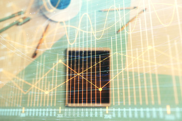 Double exposure of forex graph on digital tablet laying on table background. Concept of market analysis