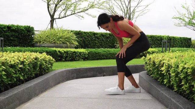 Beautiful sport woman twitch her leg, thigh and sprain ankle during jogging on the lane. New runner woman does not streching legs, warm up before jogging that make her get spasm, injured while running