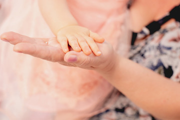 hand of a one-year-old child on the hand of a grandmother