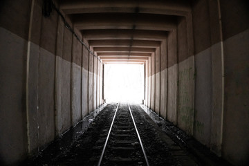 Fototapeta premium Wyjście z placu, puste, betonowe, tunel kolejowy. Wewnątrz jednokierunkowego tunelu kolejowego.