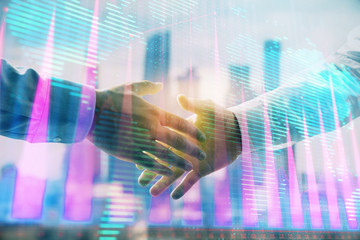 Fototapeta na wymiar Double exposure of financial chart and world map on cityscape background with two businessmen handshake. Concept of international investment