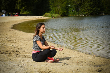 jeune femme faisant du yoga au bord de mer