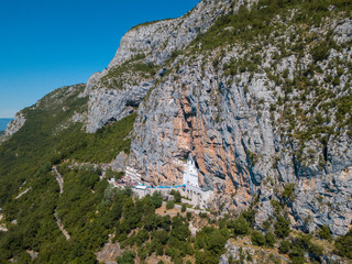 Aerial view of The Monastery of Ostrog, Serbian Orthodox Church situated against a vertical background, high up in the large rock of Ostroška Greda, Montenegro. Dedicated to Saint Basil of Ostrog 
