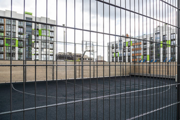 Basketball court behind metal mesh in dormitory district
