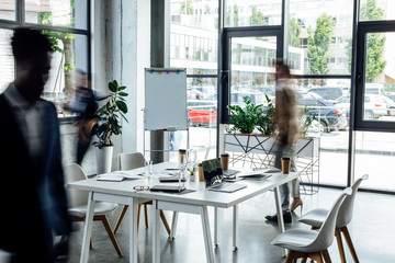 silhouettes of four multiethnic colleagues working and walking in office