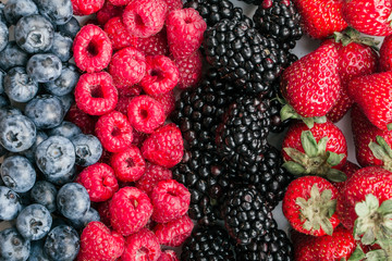 Fresh Summer Berries mix Background with Strawberry, Raspberry, Red currant, Blueberry and Blackberry.