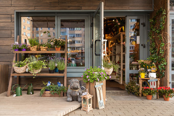 Cosy floral shop with shelves of flowers and garden decorations - obrazy, fototapety, plakaty