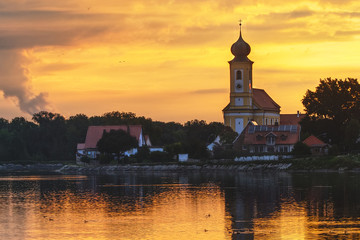 Fototapeta na wymiar Village with church on sunset