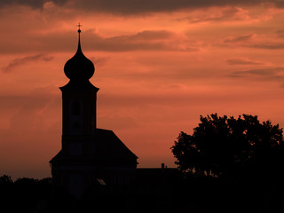 Village with church on sunset