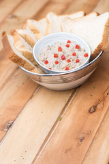 Tuna dip with bread and paprika on a wooden table