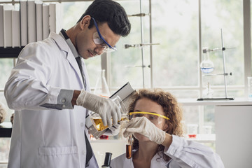 Team of Medical Research Scientist Conducts Experiments in Laboratory with Microscope, Test Tubes, Micropipette and other equipment.