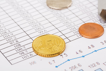 Finance Concept. Financial reports, euro coins, US coin  on business chart.