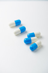 Tri-Creatine Malate capsules. Bodybuilding food supplements on white paper background. Close up. Copy space. 