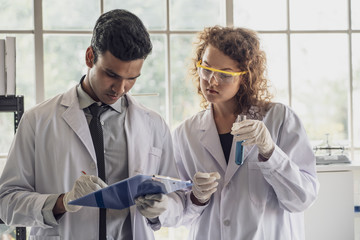 Team of Medical Research Scientist Conducts Experiments in Laboratory with Microscope, Test Tubes, Micropipette and other equipment.