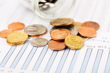 Financial chart and bottle of coins.