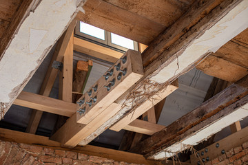 in laborious work an old house is restored, whereby old beams are strengthened with new ones