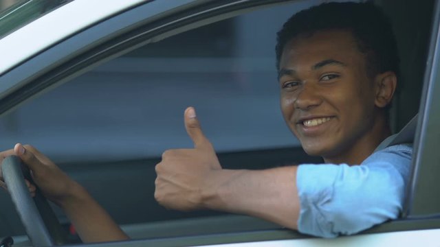 African-American Teen Boy In Car Showing Thumbs Up, Getting Driver License