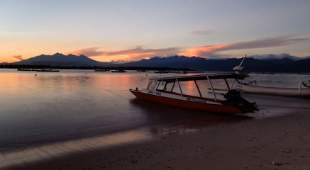 A sunrise in bali with a boat