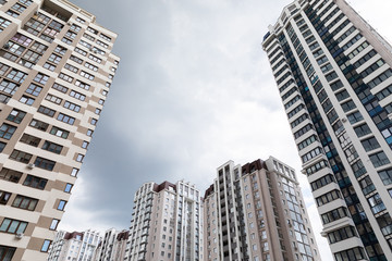 Fototapeta na wymiar Ground view of cutting-edge architecture apartment buildings at dormitory district, cloudy sky background