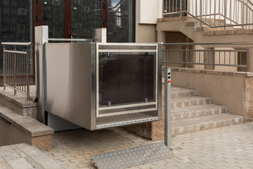 Cutting-edge metal city stair lift, platform lift, disabled persons lift outside apartment building, low angle view