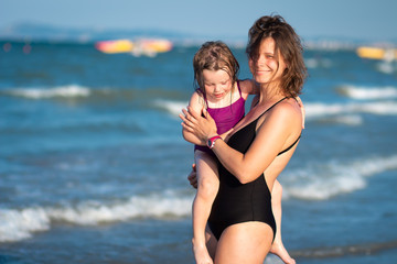 Mother and daughter having happiness on sea beach together. Family on sea vacation
