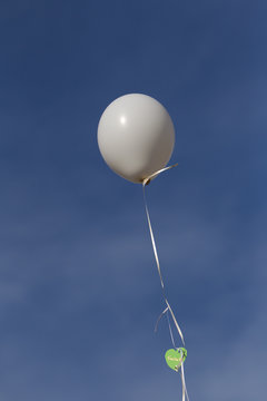 weißer Luftballon vor blauem Himmel