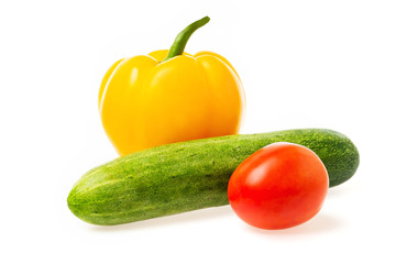 Closeup image of vegetables festive three colors group. Red tomato, green cucumber and yellow pepper isolated at white background.