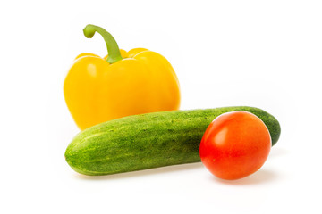 Closeup image of vegetables festive three colors group. Red tomato, green cucumber and yellow pepper isolated at white background.