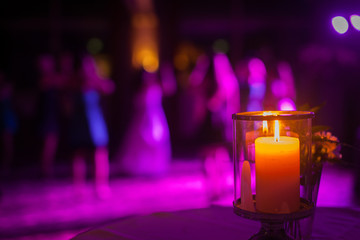 Kerze auf Hochzeitsfeier, Tanzfläche im Hintergrund