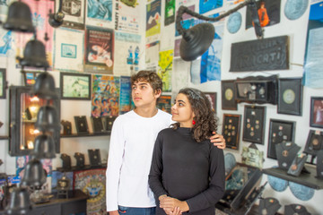 Couple of young teenagers looking at art and gift shop