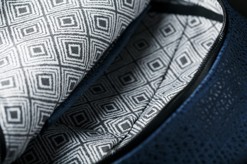 Close-up inside pockets, elements of a blue backpack made of genuine leather on a dark background, handmade.