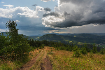 A wonderful walk along the ridge in the Ukrainian Carpathians amidst the scent of flowers, the dramatic cloudy sky before the rain with a thunderstorm.