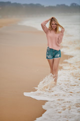 Naklejka premium A beautiful girl walks along the beach and rejoices